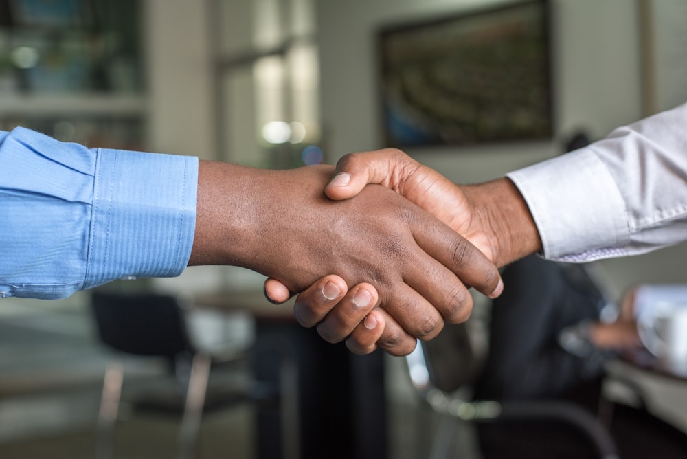 A candidate and hiring manager shaking hands after an offer