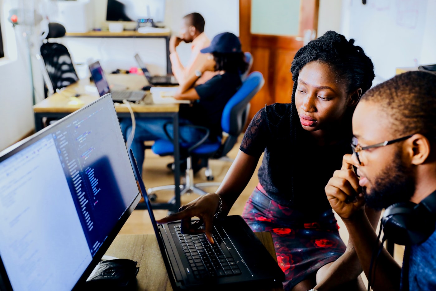 A team of engineers reviewing work together on laptops